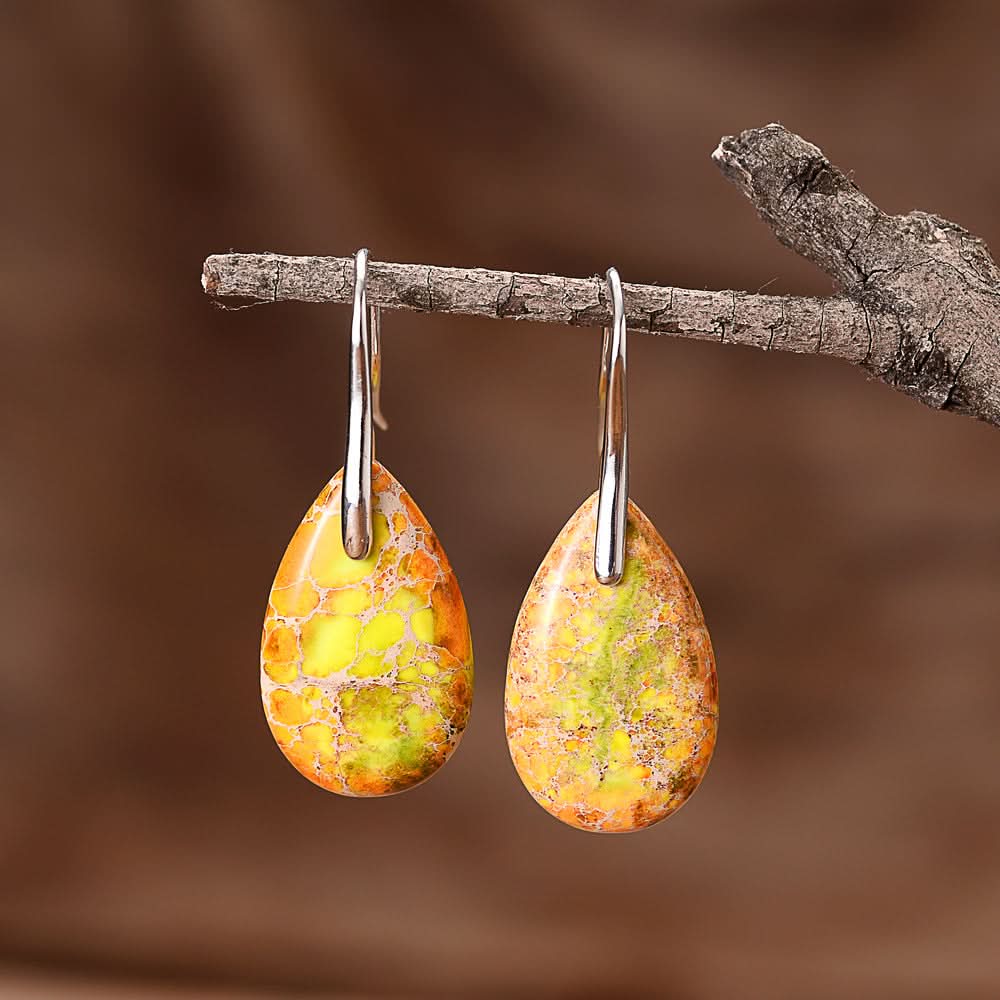 Teardrop stone earrings with yellow, orange, and green marbled patterns and silver hooks.